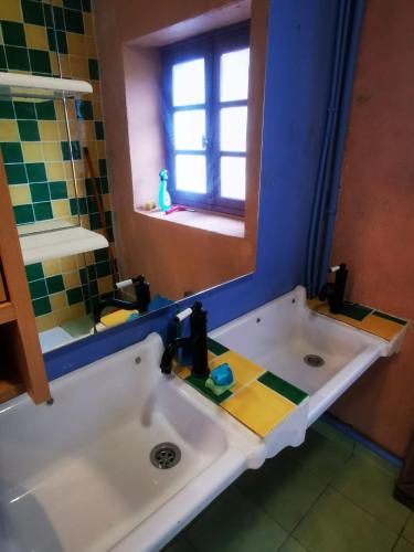 une salle de bain avec un lavabo et un miroir dans l'établissement Auberge du Lama Zébré mixte, à Penmarcʼh