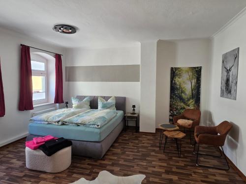 a bedroom with a bed and a chair at Altstadt-Domizil in Annaberg-Buchholz