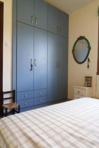 a bedroom with a bed with blue cabinets and a mirror at Bella Casa in Alexandroupoli
