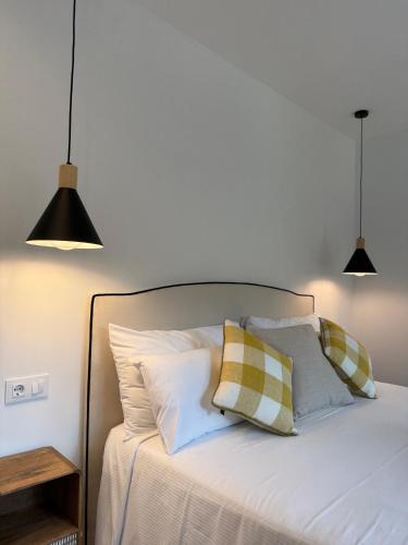 a bed with two lamps and two pillows on it at Hotel Convent de Begur in Begur