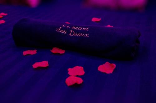 a group of red hearts on a purple blanket at Le secret des déoux love room in Forcalqueiret