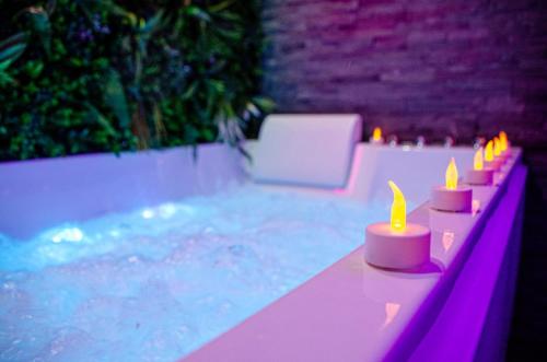 une rangée de bougies posées à côté d'une piscine dans l'établissement Le secret des déoux love room, à Forcalqueiret