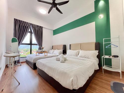 a bedroom with two beds and a ceiling fan at The Cove Hillside Residence Ipoh by PLY Home in Ipoh