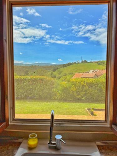a window over a sink with a view of a field at La casita de Vera in Cabezón de la Sal