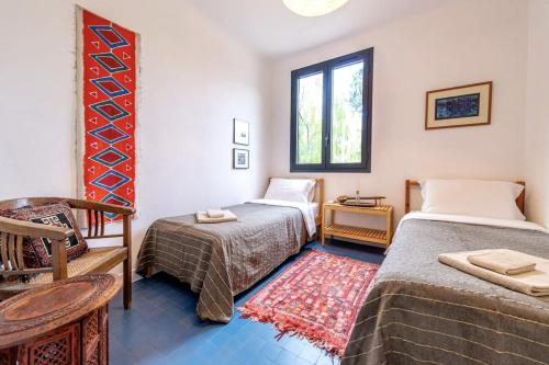 une chambre avec deux lits et une chaise et une fenêtre dans l'établissement Magical Villa with Secluded Garden - Beach, Port & Centre, à Vallauris