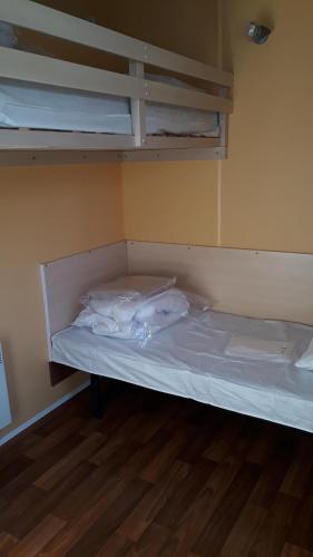 an empty bunk bed in a room with wooden floors at Camping Le Balcon de Chartreuse in Miribel-les-Échelles
