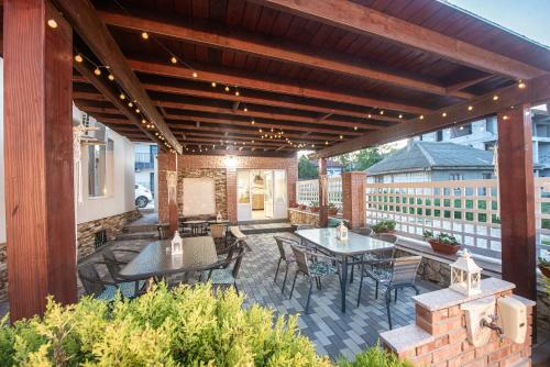 a patio with tables and chairs on a building at Vila Amir Vama Veche in Vama Veche