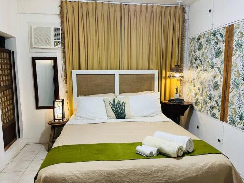 a bedroom with a large bed with towels on it at Anton & Isabel HomeStay Bangued in Bangued