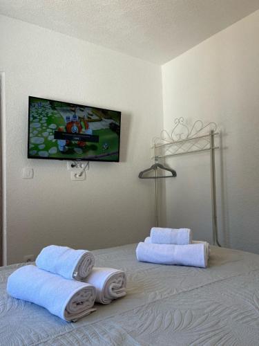 a bedroom with a bed with towels and a tv on the wall at Apartmani Šegota in Lun