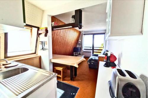 - une cuisine avec évier et table dans une caravane dans l'établissement Les grands chalets, à Chaillol