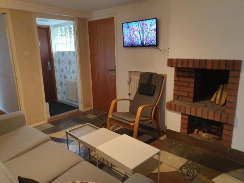 a living room with a couch and a fireplace at Cozy apt in 50s villa 10 min tram ride to city in Gothenburg