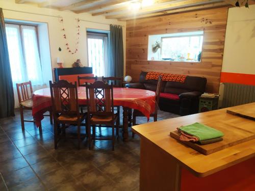 une cuisine et une salle à manger avec une table et des chaises dans l'établissement l'heureux bazar, à Saint-Nectaire