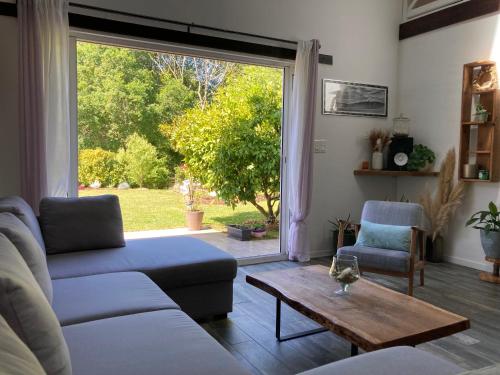 un salon avec un canapé, une table et une fenêtre dans l'établissement La Kasa Poza, à Biaudos