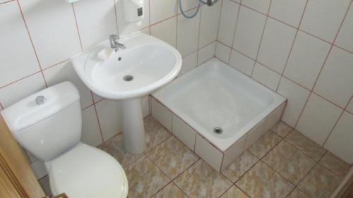 a white bathroom with a sink and a toilet at Sea Breeze Costinești in Costinesti