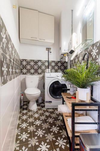 La salle de bains est pourvue de toilettes et d'un lave-linge. dans l'établissement Le 2e Colombier, à Colombes
