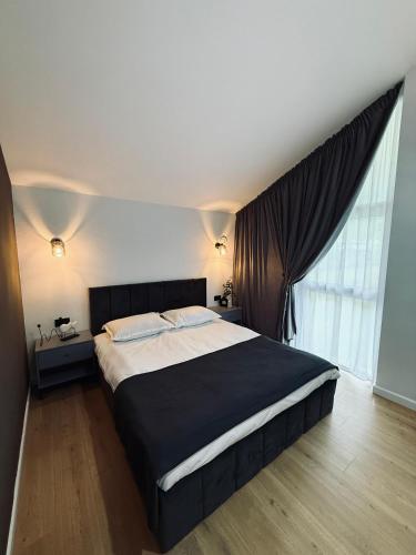 a bedroom with a large bed and a large window at Cozy HillSide in Statiunea Borsa