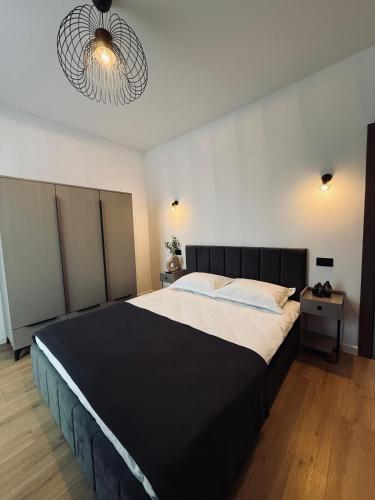 a bedroom with a large bed with a black headboard at Cozy HillSide in Statiunea Borsa