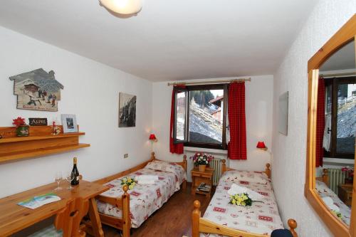 una camera con letto, scrivania e tavolo di Vista Livigno - Happy Rentals a Livigno