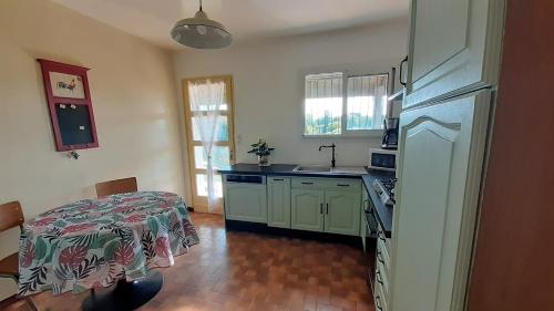 une cuisine avec une table et un comptoir dans l'établissement La Maison LEON, à Ychoux