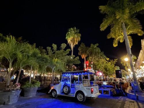 a utility truck parked next to palm trees at night at Promo! 2BR-Pool-Views-King Bed-Walk 2 Beach-5 Star Area in Mazatlán
