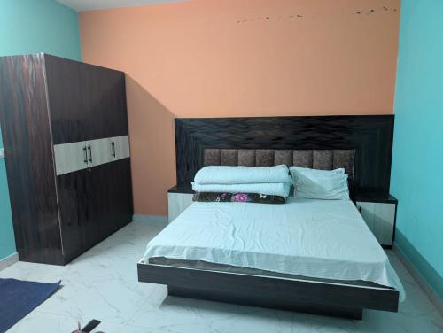 a bedroom with a large bed with white sheets and pillows at Hilltop Heaven - One Bedroom Apartment in Mussoorie