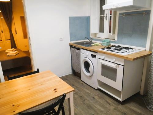 a kitchen with a stove and a washing machine at Stanze a Sud in Ragusa