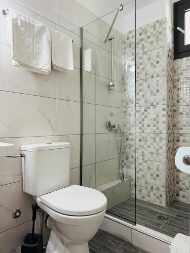 a bathroom with a toilet and a glass shower at INO Luxury Rooms in Paralia Katerinis