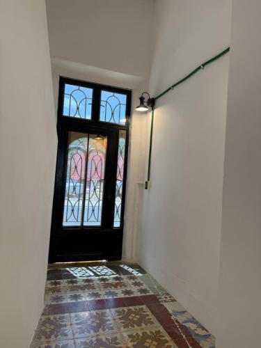 a hallway with a black door and a window at Casa Bernarda in Mérida