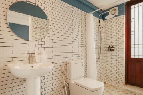 a bathroom with a sink and a toilet and a mirror at House Of Papa Bangkok Siam in Bangkok