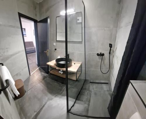 a bathroom with a glass shower and a sink at Island Chill Apartments ONE in Kali