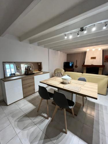 une cuisine et une salle à manger avec une table et des chaises dans l'établissement Misenga, à Beaulieu-sous-la-Roche