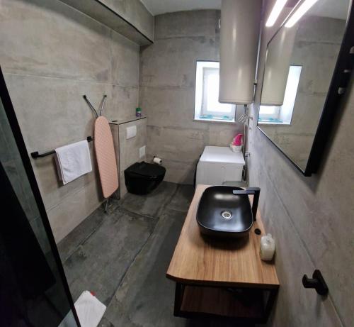 a small bathroom with a black iron on a wooden table at Island Chill Apartments ONE in Kali