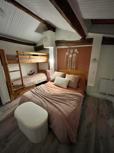 - une chambre avec un grand lit et un tabouret blanc dans l'établissement Misenga, à Beaulieu-sous-la-Roche