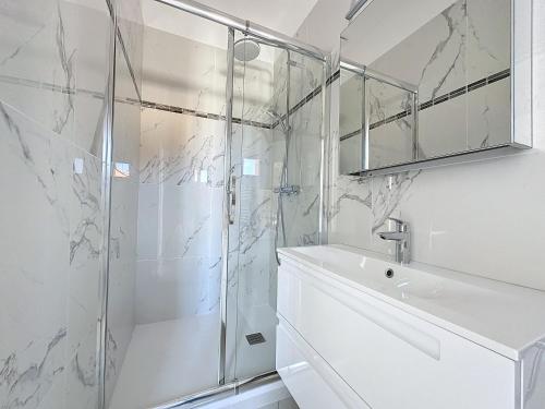 une salle de bain blanche avec une douche et un lavabo dans l'établissement Brand new 1 bedroom flat, 5 mins walk to Monaco centre, à Beausoleil