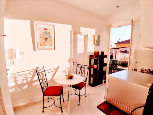 une cuisine avec une table, des chaises et un réfrigérateur dans l'établissement Brand new 1 bedroom flat, 5 mins walk to Monaco centre, à Beausoleil