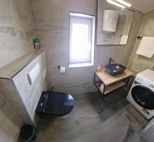 a bathroom with a black toilet and a sink at Island Chill Apartments ONE in Kali