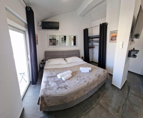a bedroom with a large bed with two towels on it at Island Chill Apartments ONE in Kali