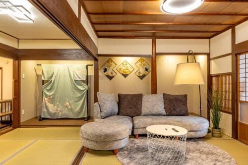 a living room with a couch and a chair at Lax奈良 奈良観光に便利な和モダン古民家 最大12名 グループや家族旅行に最適 in Nara