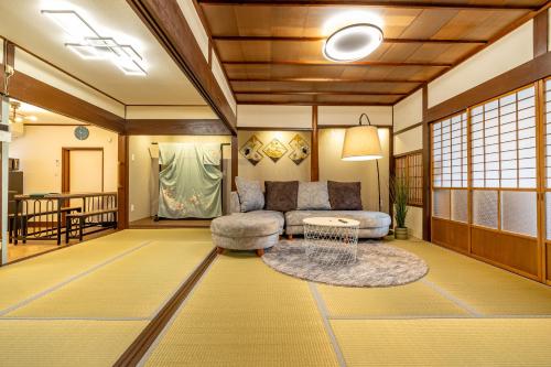 a living room with a couch and a table at Lax奈良 奈良観光に便利な和モダン古民家 最大12名 グループや家族旅行に最適 in Nara