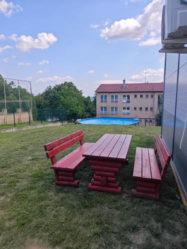 a picnic table and two benches in a park at Chatka Katka in Klokočov