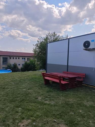 a red picnic bench in a field with a large screen at Chatka Katka in Klokočov