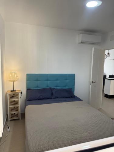 バルバテにあるApartamento Vista al mar primera en la playaのベッドルーム1室(青いヘッドボード付)
