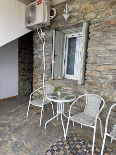 a patio with a table and chairs and a fan at Tinos dream sea ,150m from the beach in Agios Sostis