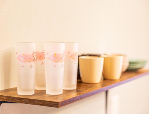 a row of white vases on a wooden shelf at Lax奈良 奈良観光に便利な和モダン古民家 最大12名 グループや家族旅行に最適 in Nara