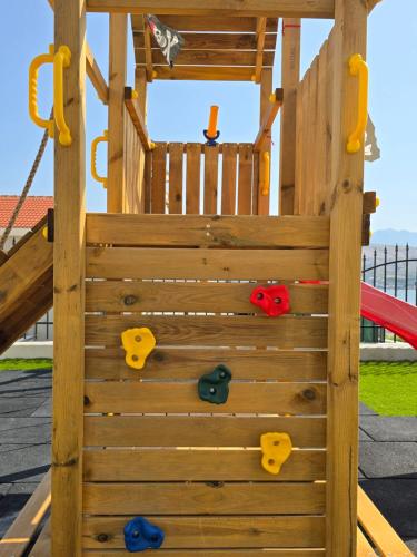 a wooden climbing frame with a playground at Family apartments Grguric in Pag