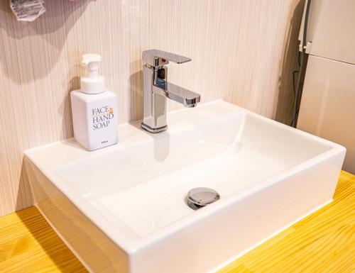 a bathroom sink with a soap dispenser on it at Lax奈良 奈良観光に便利な和モダン古民家 最大12名 グループや家族旅行に最適 in Nara
