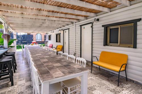 a row of chairs and a table on a patio at בקתות ילוז של רשת לב הגולן - 6 צימרים מקסימים עם בריכה משותפת ליד הכנרת in Yavneʼel