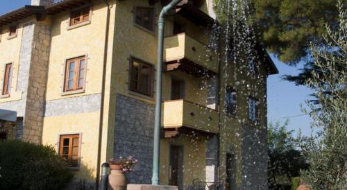 a building with a water fountain in front of it at Tenuta La Lupa in Castellina Marittima