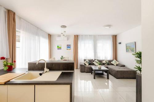 a kitchen and living room with a couch and a table at Rooftop Spa in Trogir