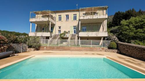 une maison avec piscine devant un immeuble dans l'établissement Bilboquet, à Vals-les-Bains